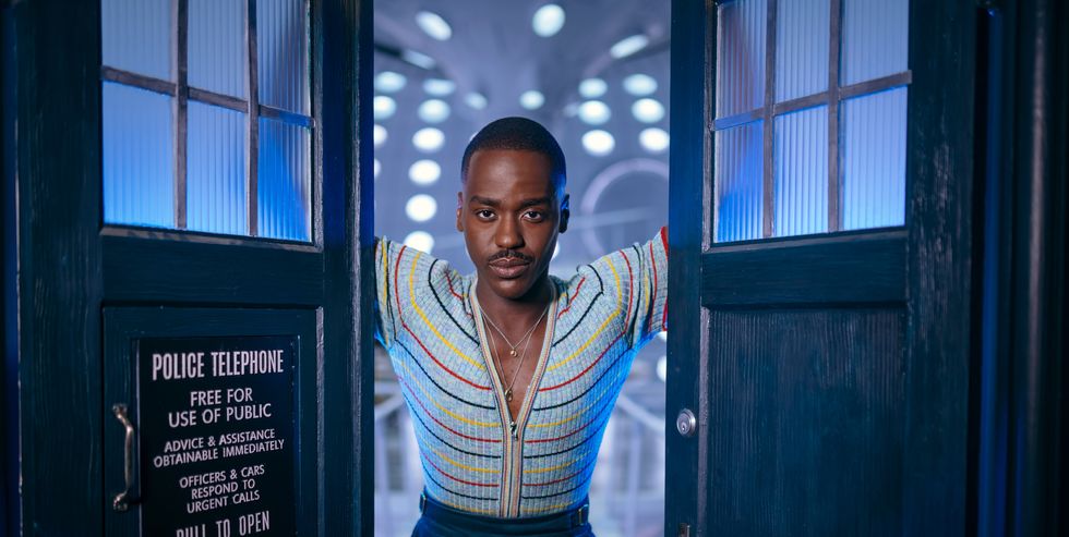 Ncuti Gatwa als fünfzehnter Arzt, der in einer Szene aus Doctor Who zwischen den offenen Türen der Tardis steht