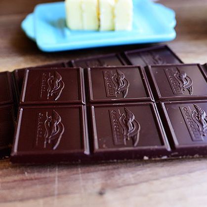bars of ghirardelli chocolate on wood with butter in back