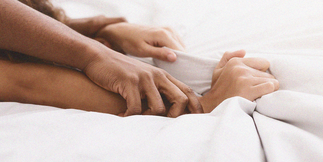 a close up of hands on a bed
