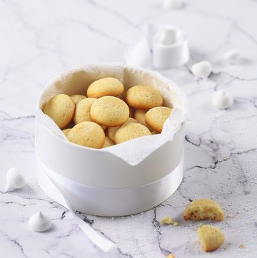 little round vanilla butter cookies, round box, plate, coffee, light marble background