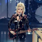 dolly parton singing and playing a guitar on stage
