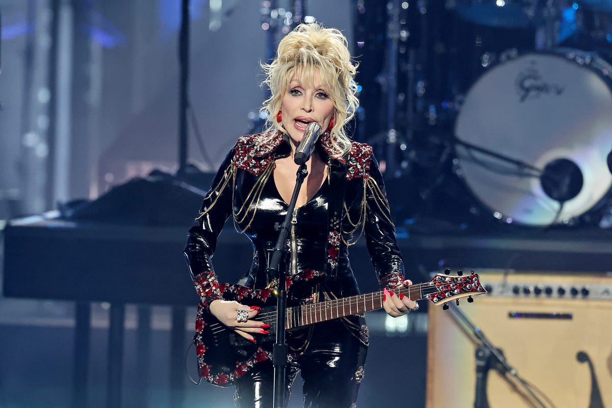 dolly parton singing and playing a guitar on stage