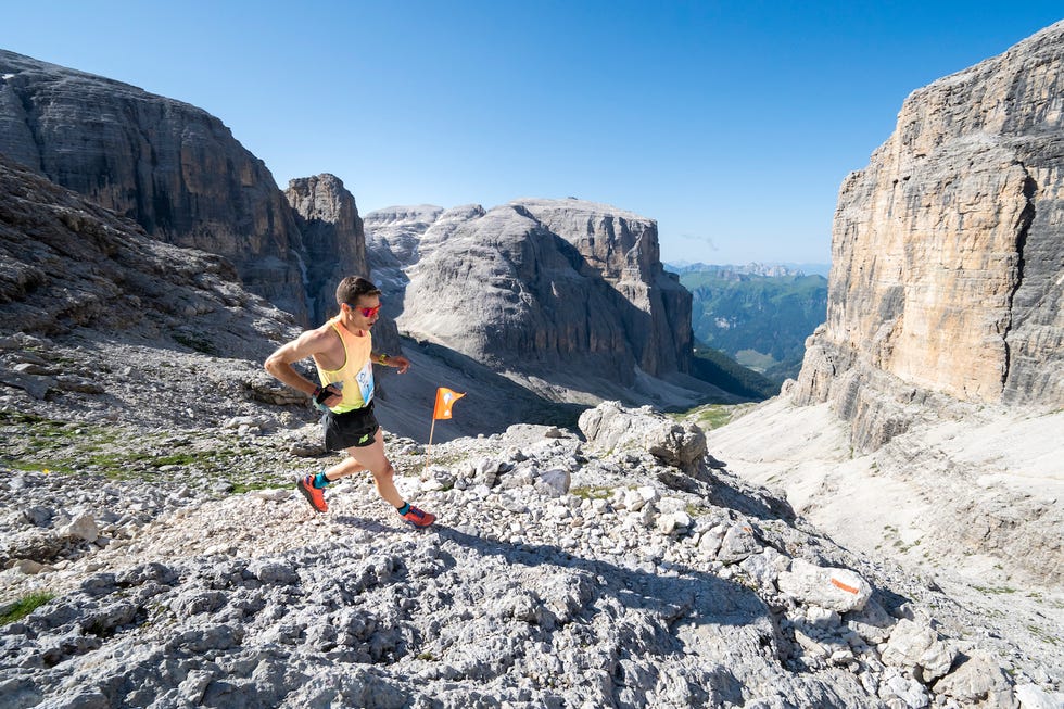 a runner navigating a mountainous trail during daylight