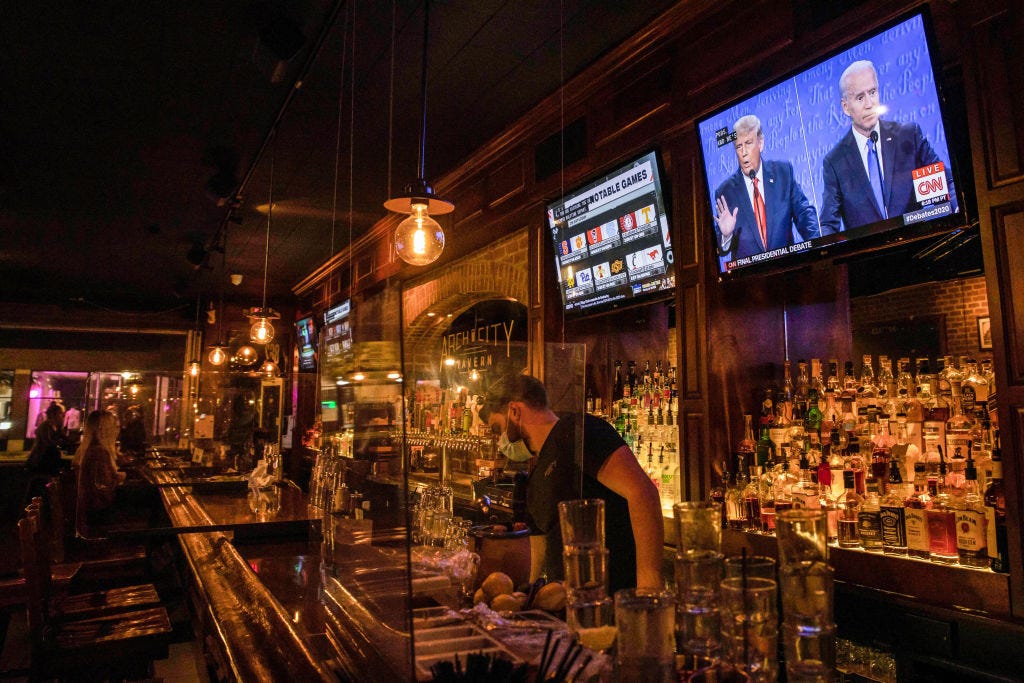 donald trump and joe biden seen speaking on a tv screen at