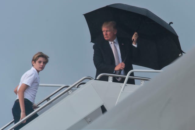 Donald Trump hogs umbrella while Melania and Baron are rained on