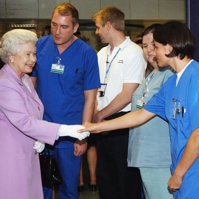 london, england   july 8  no uk sales for 28 days hm queen elizabeth ii, the queen, is introduced to accident and emergency staff a  e by senior charge nurse paul courtman during her visit to the royal london hospital to meet staff and victims of the terrorist bomb explosions on june 8, 2005 in london, england  photo by pooltim graham picture librarygetty images