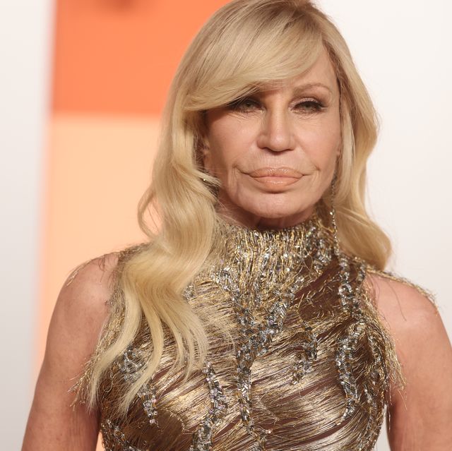 donatella versace poses in gold sleeveless gown