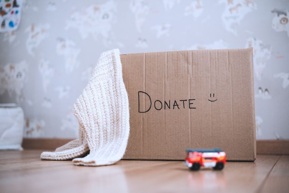 donation cardboard box with childrens clothes and toys, charity and volunteering concept