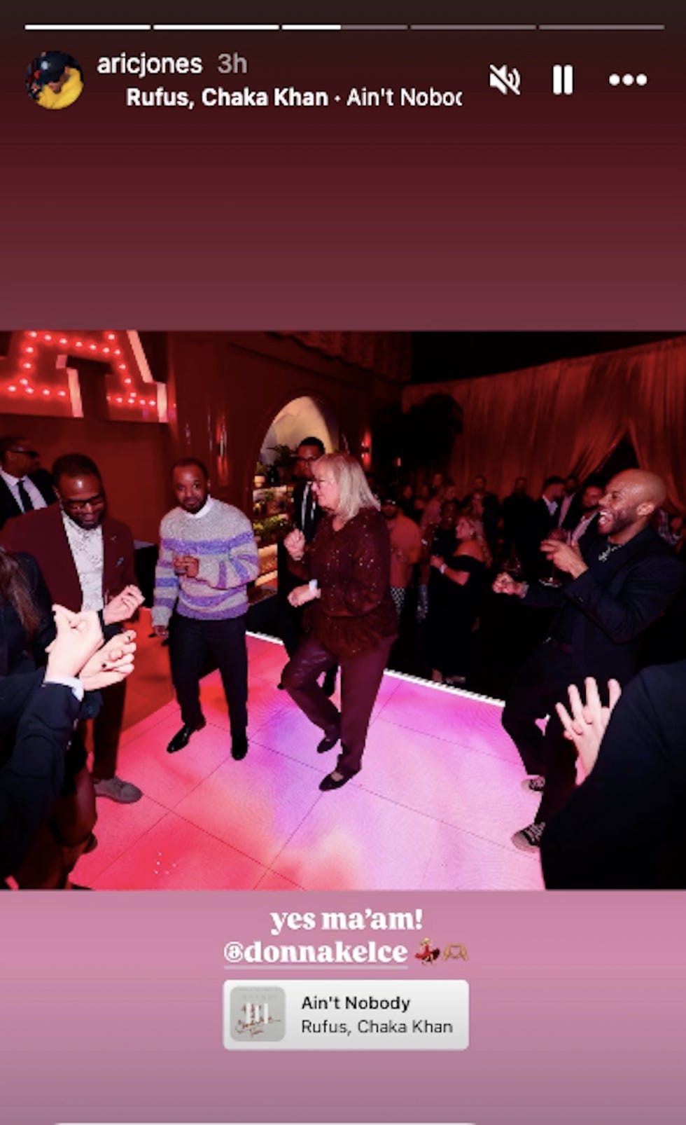 group of people dancing at an event with colorful lighting