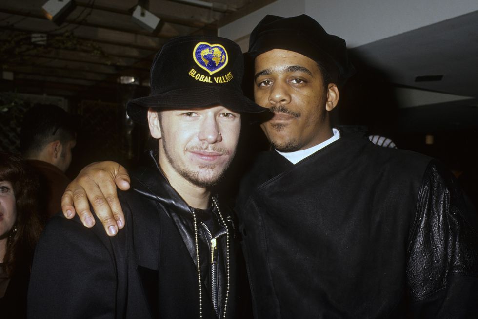 donnie wahlberg and maurice starr look at the camera and stand together for a photo, both men wear black hats and black jackets