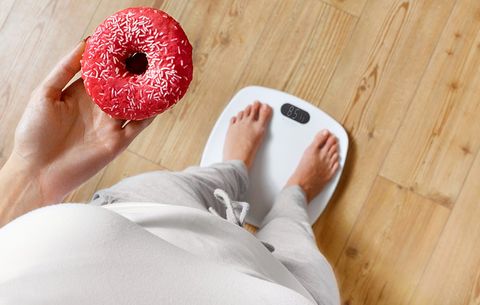 Standing on the bathroom scale with a donut