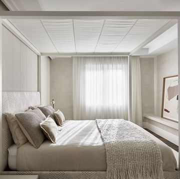 dormitorio con cama con dosel y tonos neutros en textiles y paredes