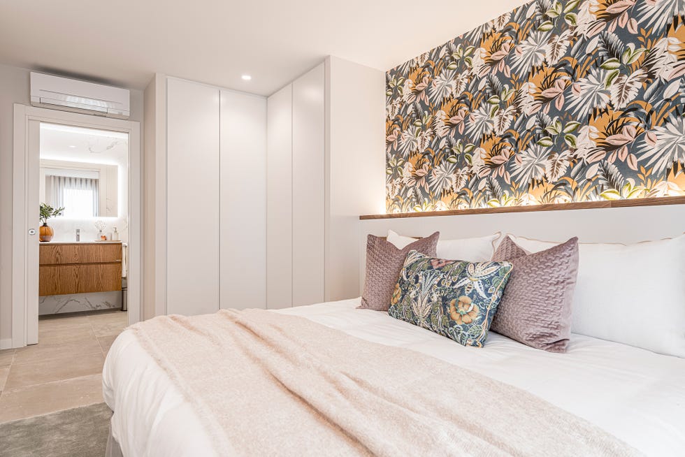 dormitorio con cabecero de obra y papel pintado floral
