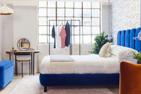 cama con estructura y cabecero de terciopelo azul, burro para la ropa y tocador