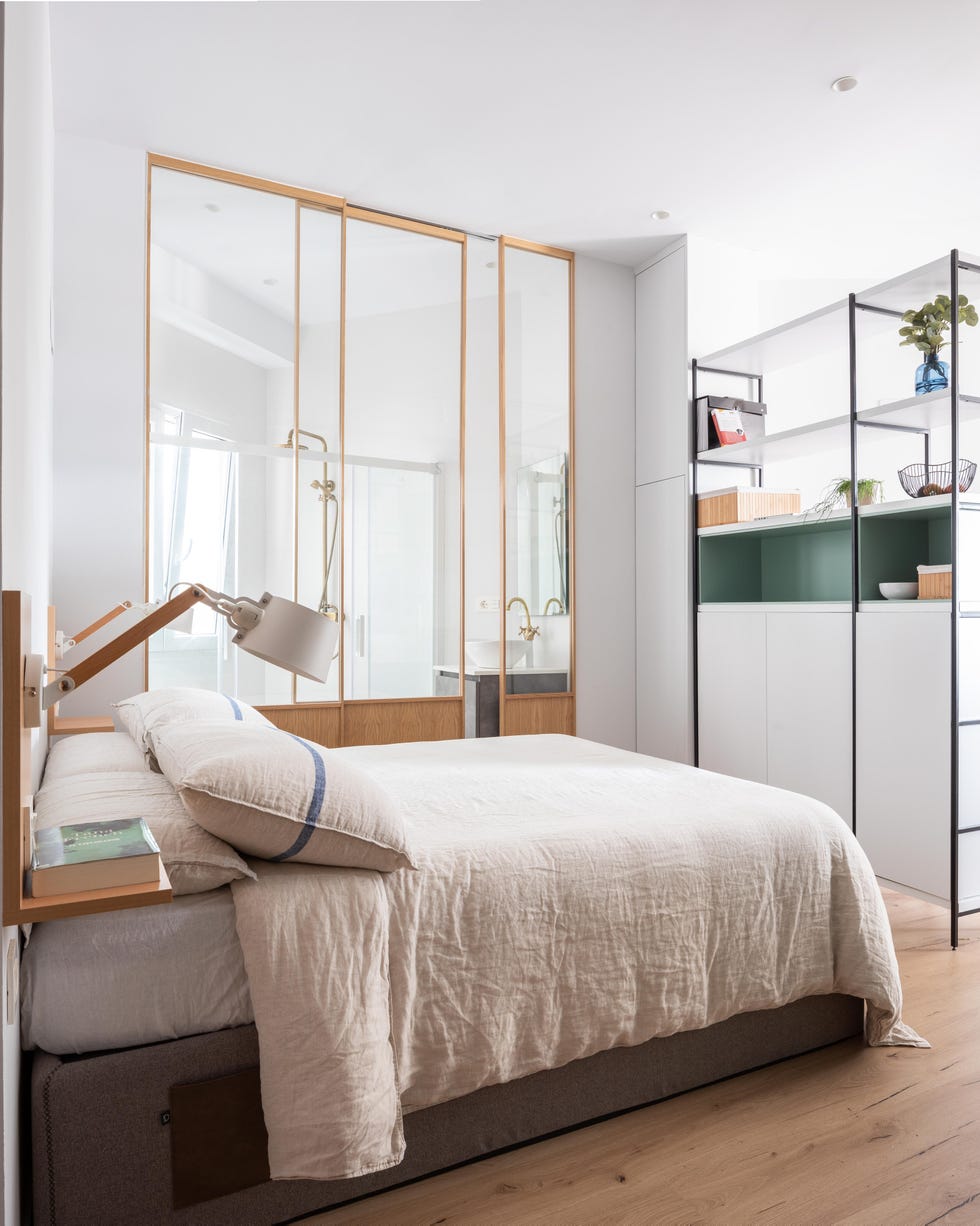 dormitorio con baño acristalado en un apartamento pequeño en san sebastián con espacio abierto