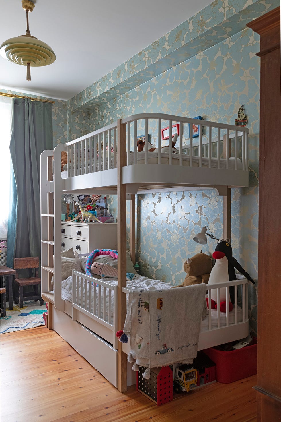 un dormitorio infantil con papel pintado en verde y con literas