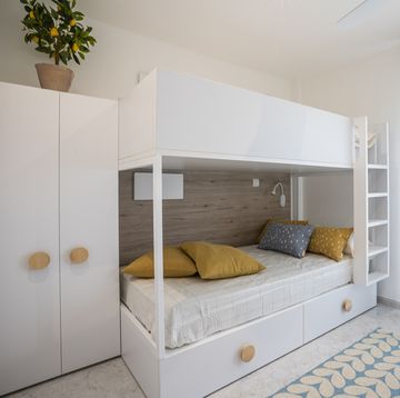 dormitorio juvenil con literas y mobiliario blanco de diseño nórdico