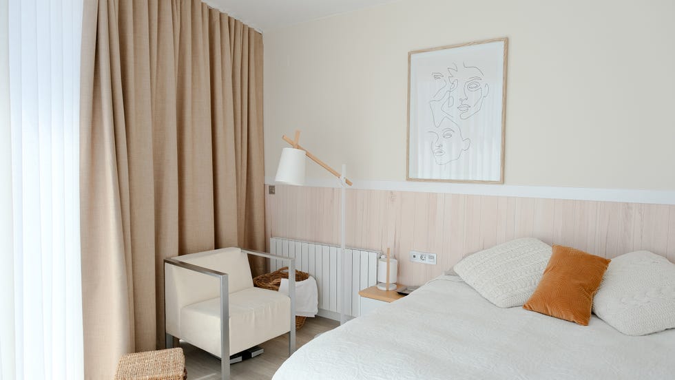dormitorio con panel de madera a media altura en la pared del cabecero
