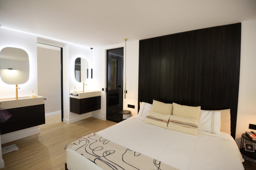 dormitorio con cabecero de palillería y baño en suite