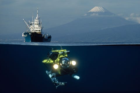 Een op afstand bestuurbaar voertuig ROV daalt af naar Suruga Bay Japan terwijl de berg Fuji op de achtergrond oprijst Deze foto was een technische uitdaging waarvoor ik een reismat nodig had ontworpen door mijn geniale collega Kenji Yamaguchi in NG photo engineering De mat blokkeerde de onderkant van de lens zodat ik de berg Fuji kon fotograferen en de film vervolgens terugrollen om Mount Fuji te blokkeren zodat ik het voertuig kon schieten Deze zeer moeilijke techniek bracht twee afbeeldingen samen op film in n frame  David Doubilet
