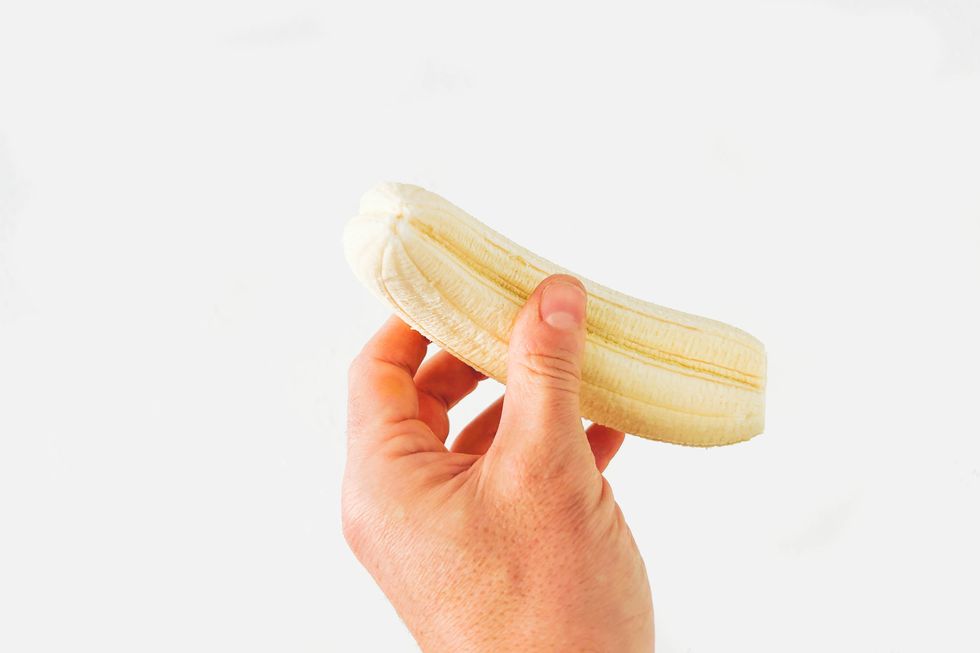 double canary islands banana in man's hand against white