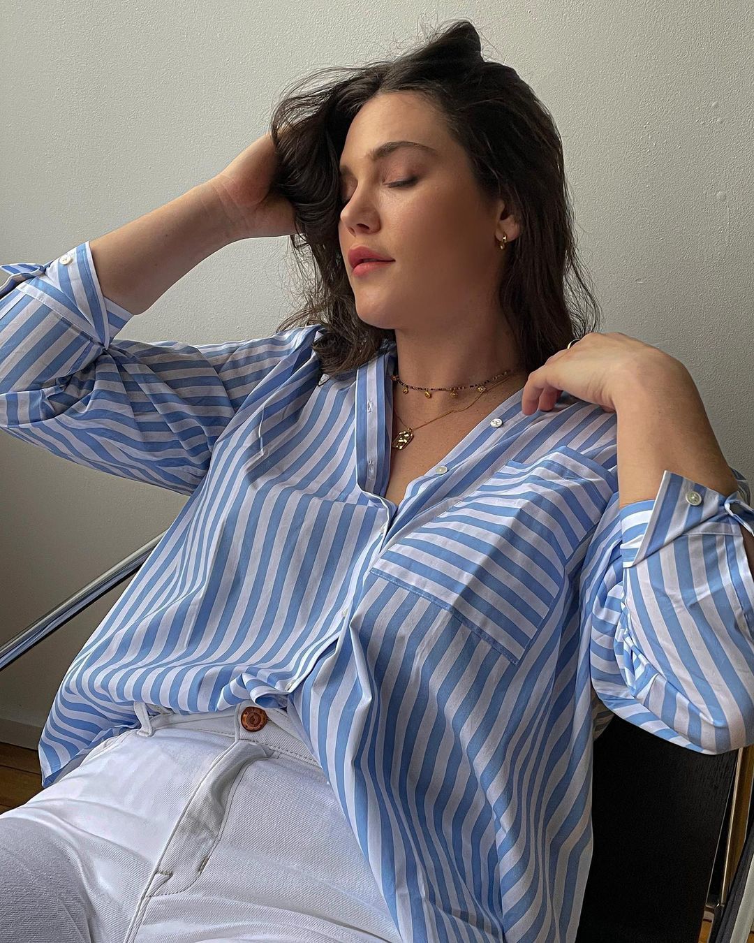 model ali tate cutler wears the ayr deep end shirt with white jeans while reclining in a chair