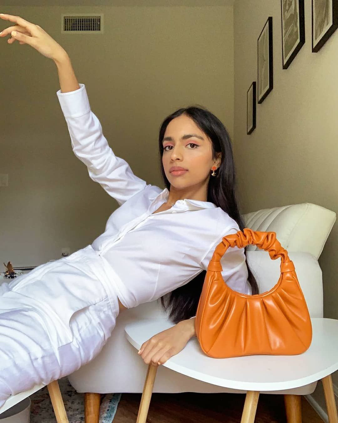 malvika sheth wears a white outfit with an orange jw pei gabbi bag