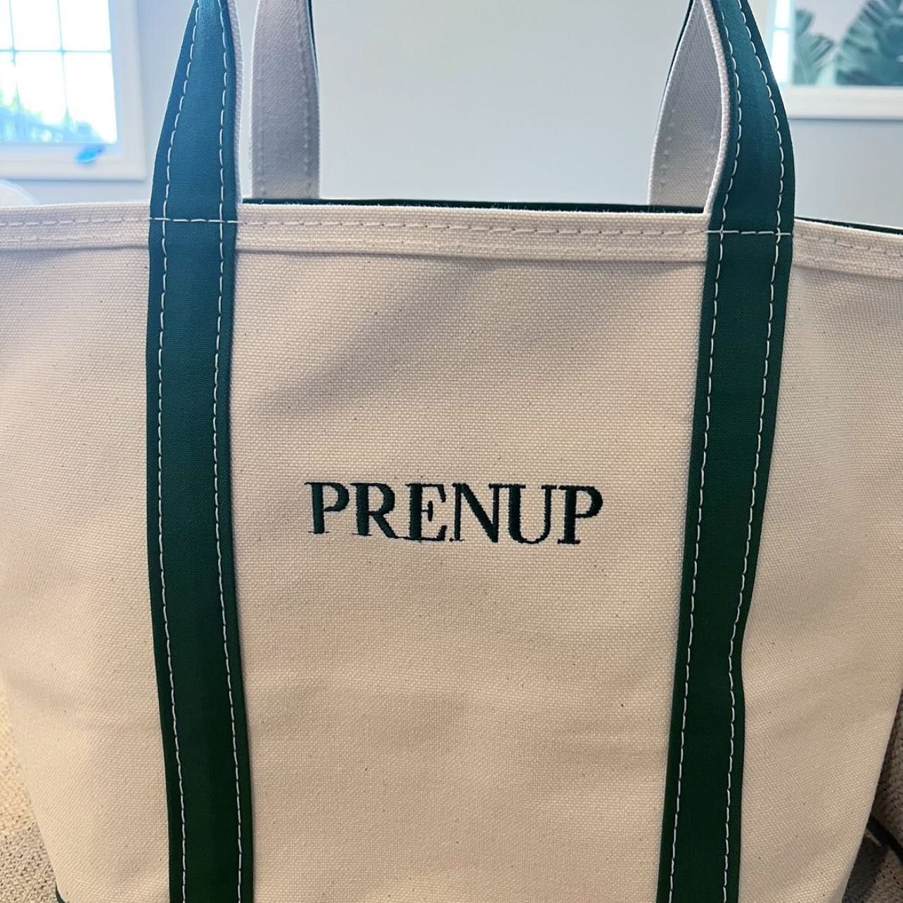 a white canvas boat and tote with the word prenup from the ll bean ironic boat and tote