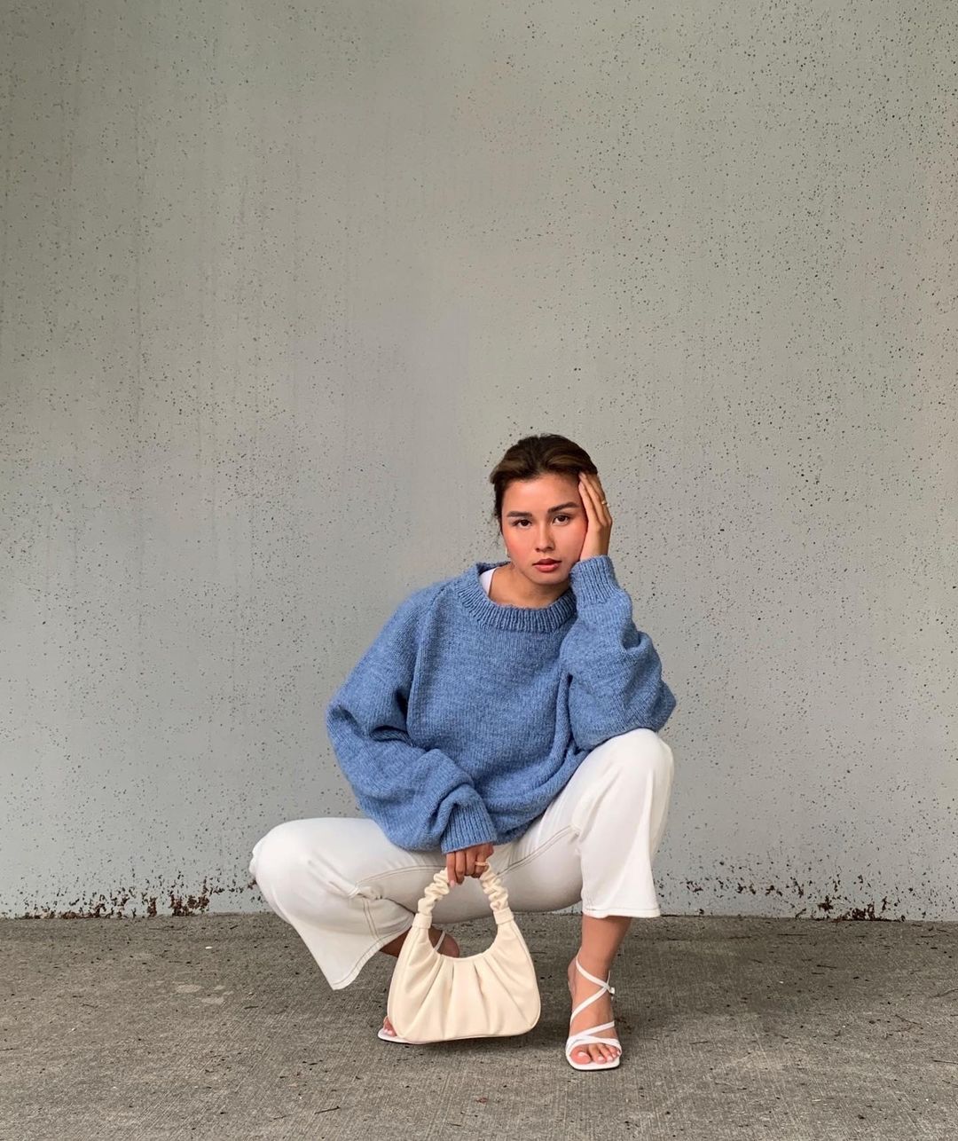 kianna kossowan holds a white gabbi bag by jw pei in front of a white wall