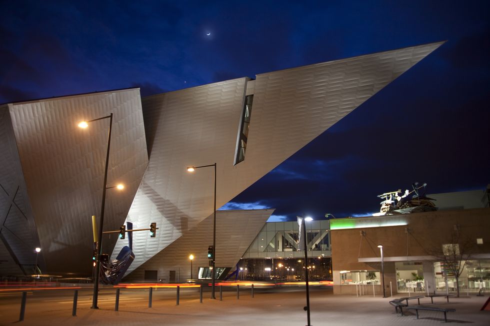 downtown traffic denver art museum with moon at night colorado