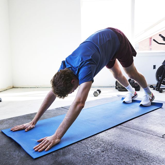 a man doing yoga on a mat in a gym