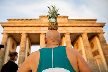 man with pineapple in front of brandenburg gate