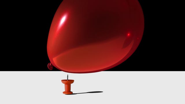 still life concept balloon being popped with pin