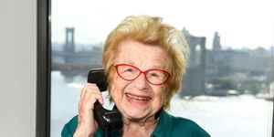 dr ruth westheimer holds a phone to her ear