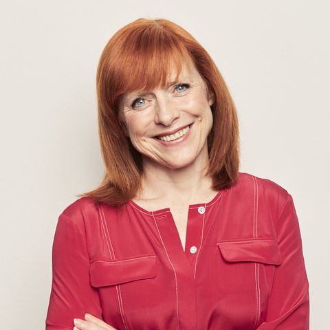 dr sarah jarvis, resident featured gp in good housekeeping professional head posed shot, red hair, red top, smiling, light background