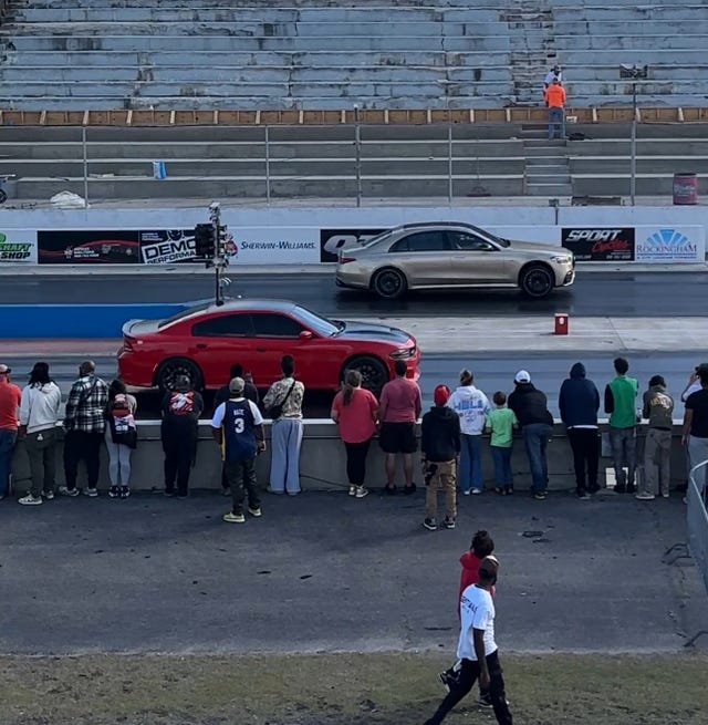 gold mercedes amg s63 vs red dodge charger at a drag strip