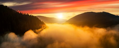 Dramatic misty sunrise in the mountains. Aerial view