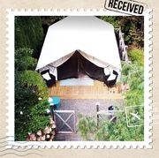 this glamping tent is tucked into an award winning, acres long garden
