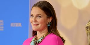 drew barrymore wearing a pink dress with cape and turquoise jewelry at daytime emmy award red carpet