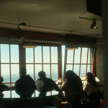 a group of people sitting at a table in front of a window
