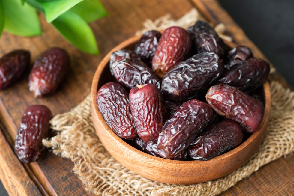 dried dates in wooden bowl