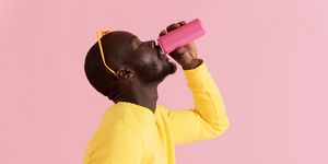 drink black man drinking soft drink on pink background portrait