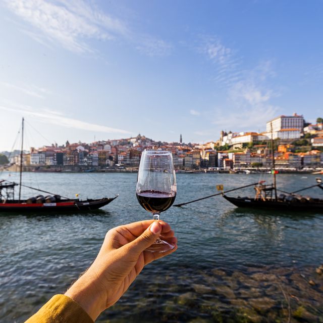 drinking port wine from a glass with view towards porto skyline, personal perspective view, porto, portugal