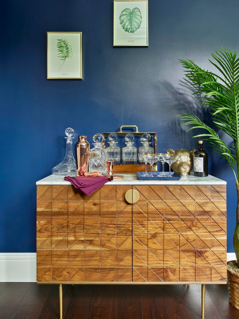 bar area with decanters and glasses on sideboard in blue room