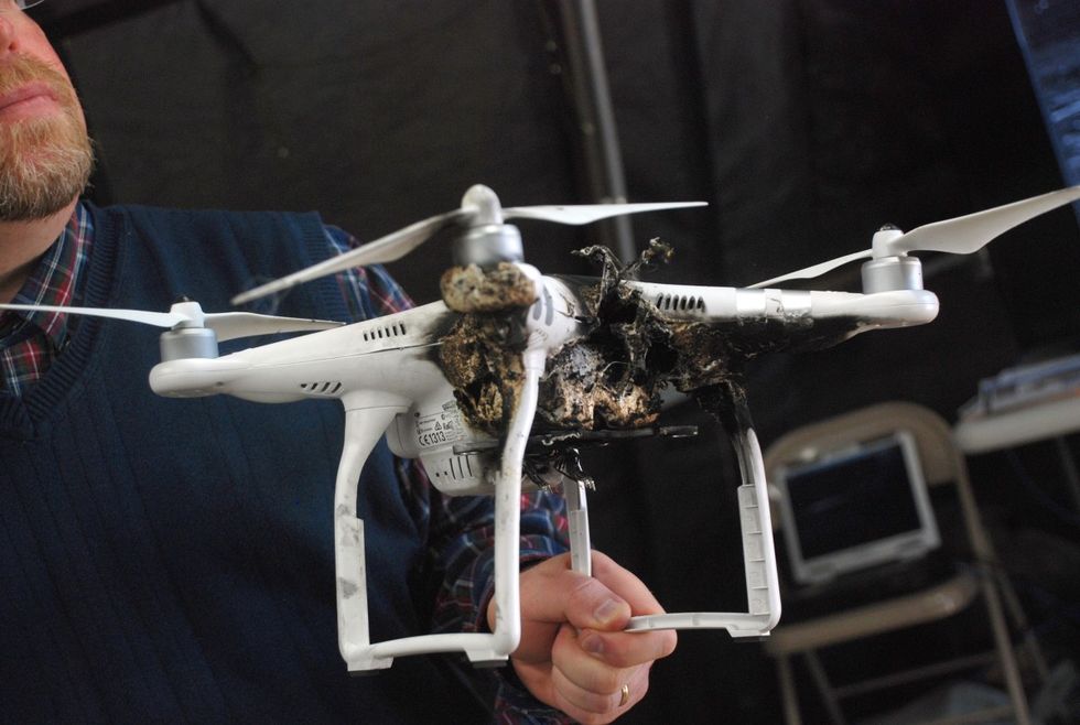 man holds drone previously heavily damaged by a high energy laser air defense weapon