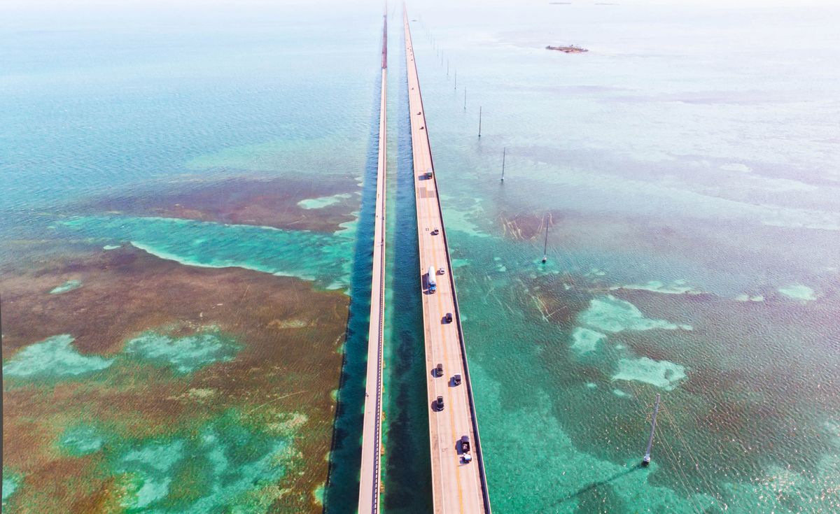 drone view of the overseas highway in florida keys with turquoise watercolor and infinite road