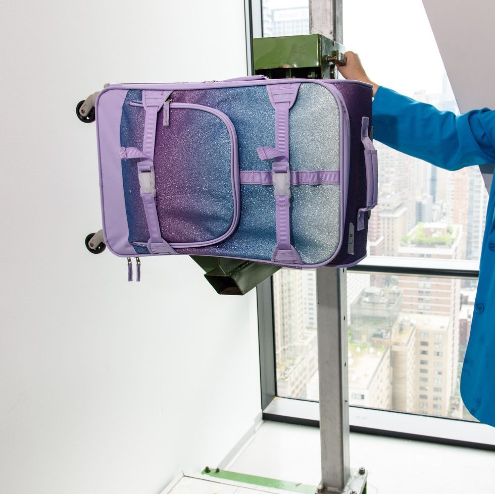a purple and blue suitcase loaded in our drop tester to measure durability