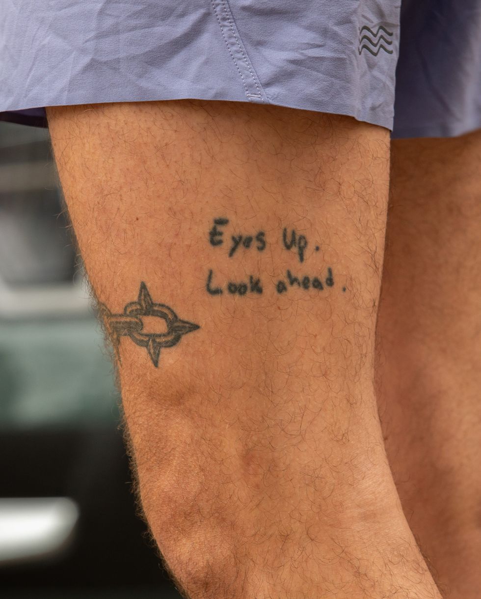 a tattoo on a leg says eyes up look ahead