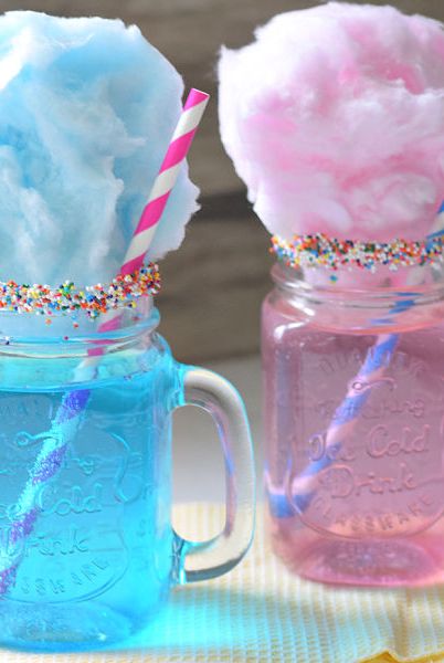 mason jars are filled with pink or blue liquid and topped with cotton candy and sprinkles, a great baby shower idea