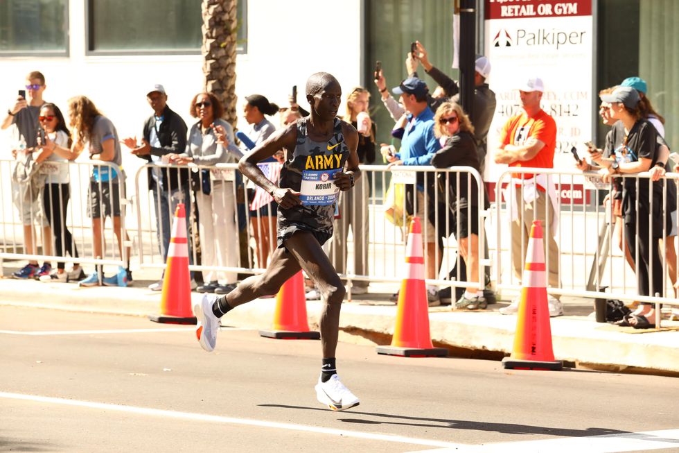 korir running on a street with people watching